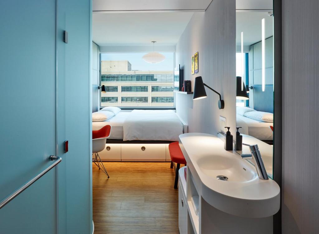 1 dormitorio con 1 cama y baño con lavabo. en citizenM Washington DC Capitol, en Washington