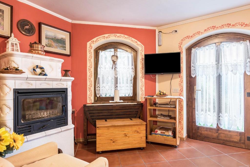 un soggiorno con camino e specchio di Appartamento Serrada a Folgaria