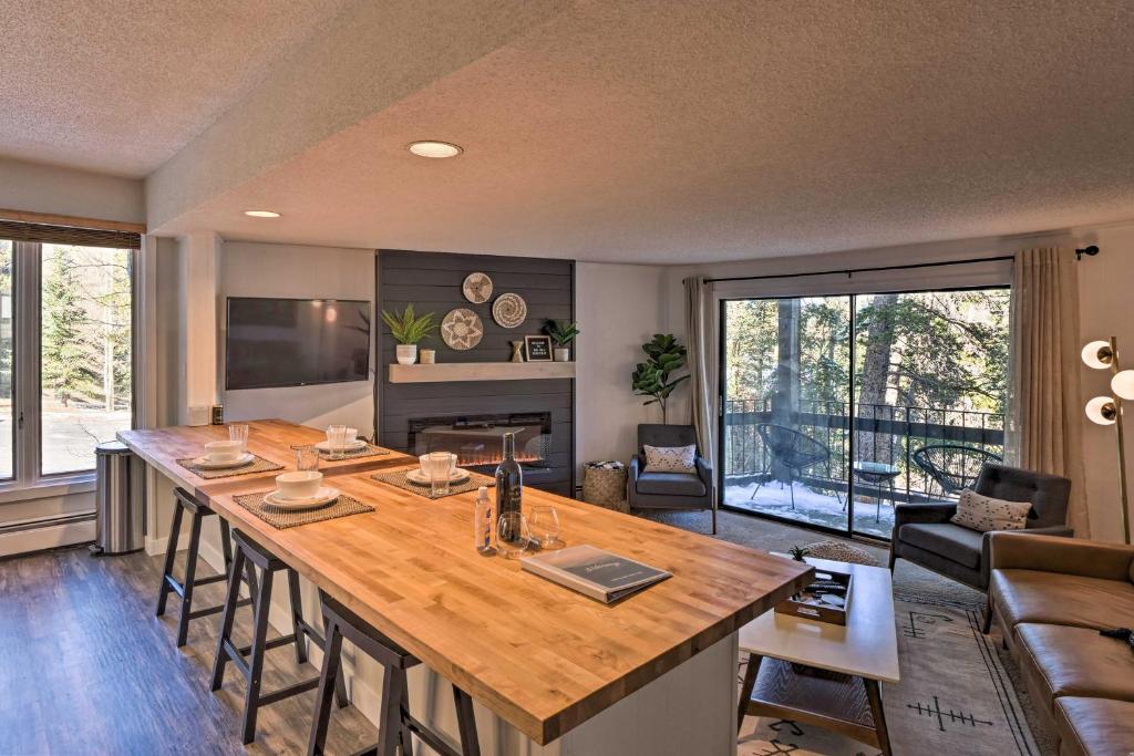 a kitchen and living room with a large wooden island at quarter Mi to Peak 8 Ski Lift Modern Breck Condo! in Breckenridge