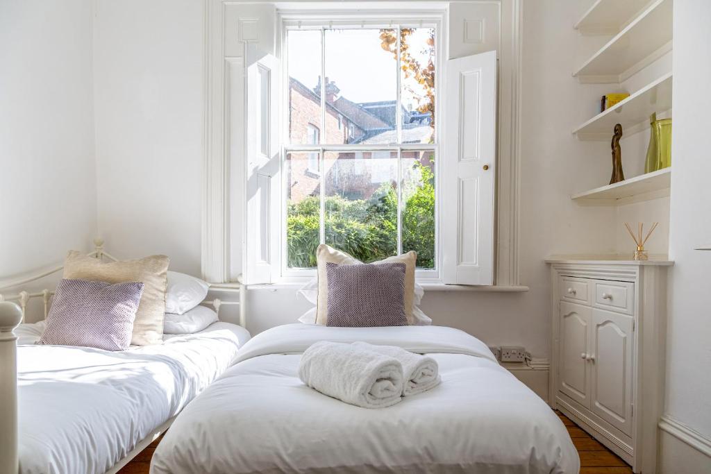 two beds in a room with a window at Amazing 5 Bed Victorian House - Clarence House in Birmingham