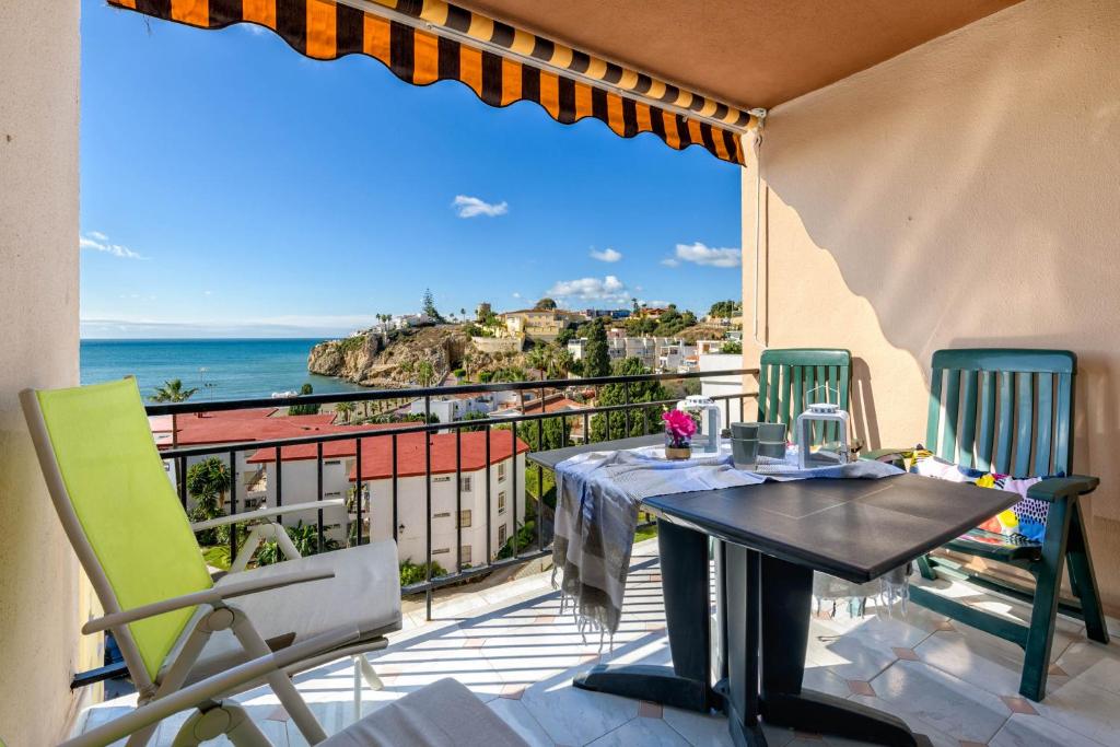 d'une table et de chaises sur un balcon avec vue sur l'océan. dans l'établissement WintowinRentals 1st Linea de playa vista al mar y piscina, à Cala del Moral