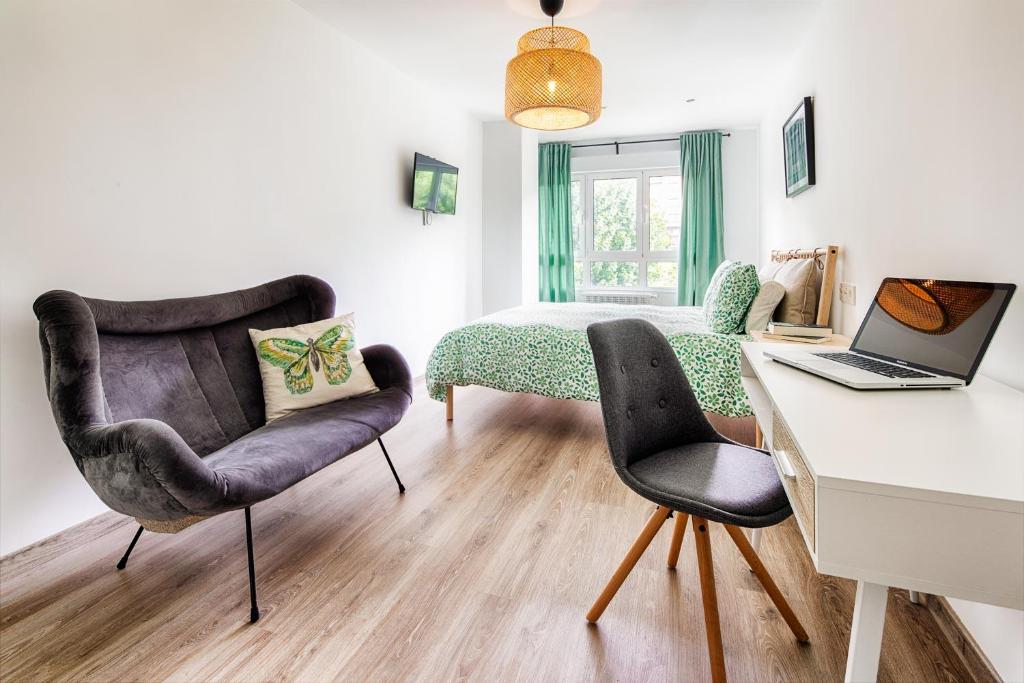 - une chambre avec un bureau, deux chaises et un lit dans l'établissement 4 estaciones - Tu hogar en el corazón de Oviedo, à Oviedo