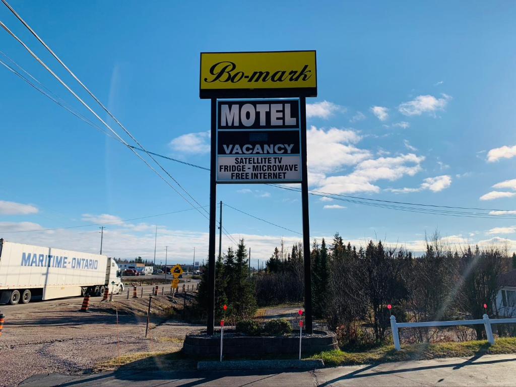 un cartel de motel en un estacionamiento con un camión en Bo-Mark Motel en North Bay