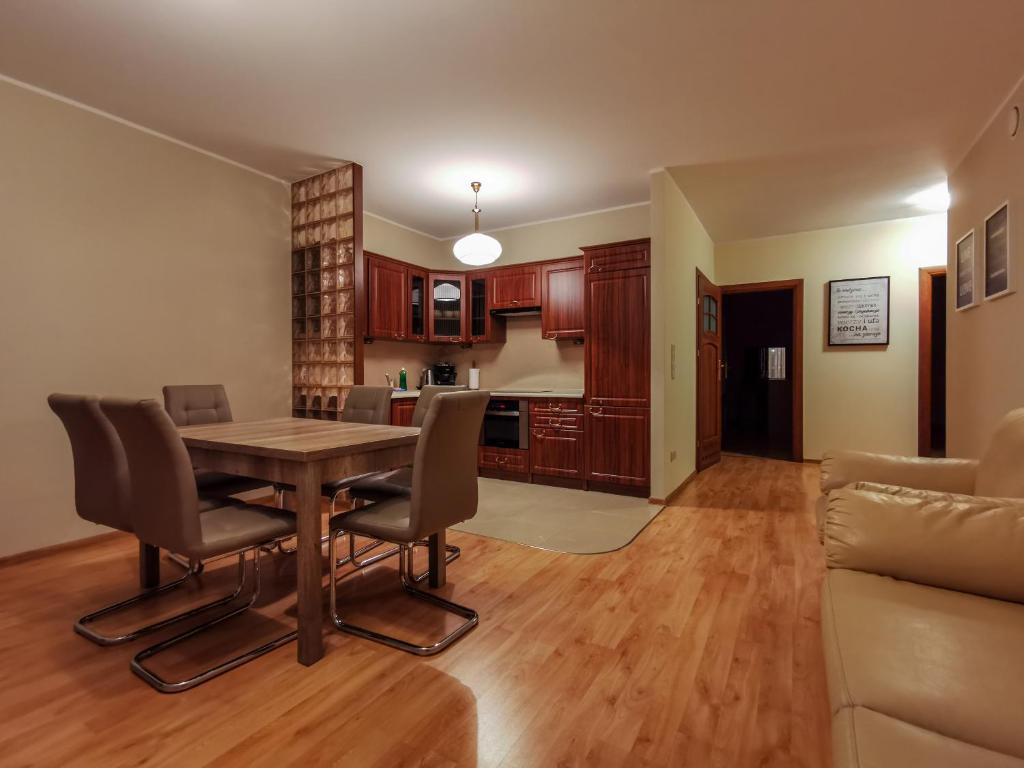a kitchen and dining room with a table and chairs at Apartament Stylowy - Zeta Park in Ustroń