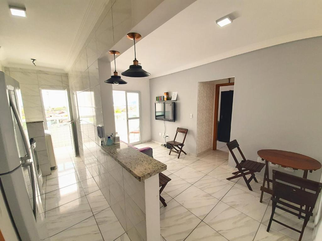 a kitchen and living room with a table and chairs at Apartamento Mirim Praia Grande in Praia Grande