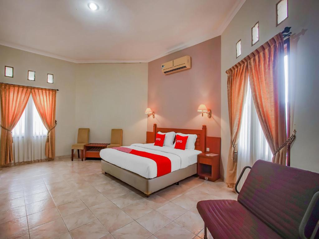 a bedroom with a bed and a couch in it at Collection O 89999 Hotel Bumi Kedaton Resort in Lampung