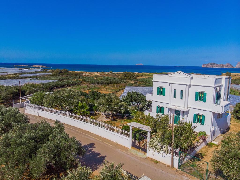 eine Luftansicht eines weißen Hauses mit dem Ozean im Hintergrund in der Unterkunft Villa Smaragdi in Phalasarna
