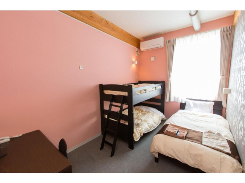 Kleines Zimmer mit einem Etagenbett und einem Schreibtisch. in der Unterkunft OGAL INN - Vacation STAY 01868v in Akaishi