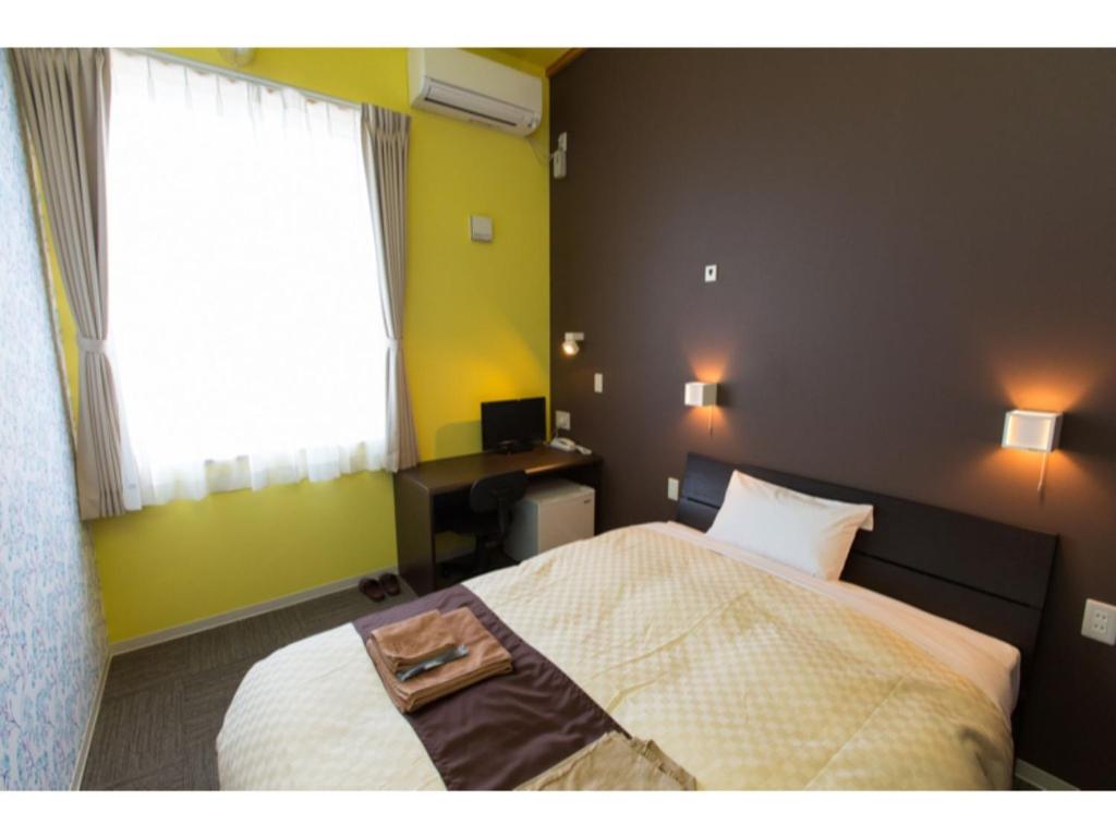 a bedroom with a bed and a desk and a window at OGAL INN - Vacation STAY 01746v 