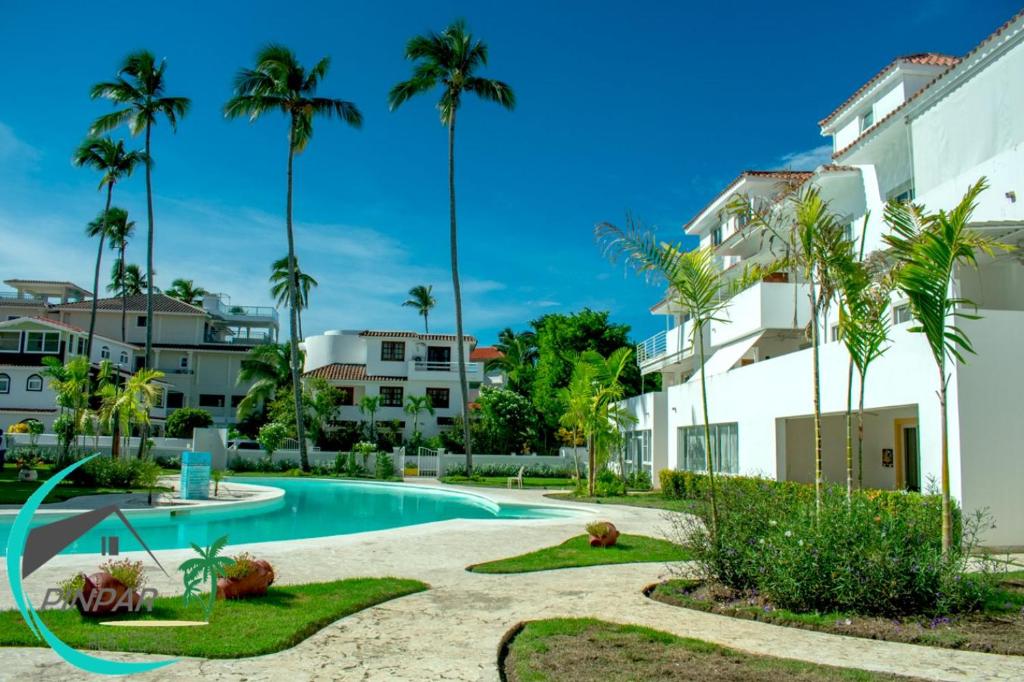 einem Pool vor einem Gebäude mit Palmen in der Unterkunft Pool Terrace, Deluxe E1, Close to Beach, 2Br, 2Bt in Punta Cana