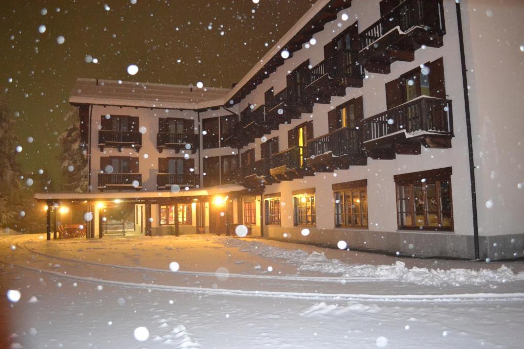 un edificio con la neve sul terreno di fronte ad esso di Park Hotel Gran Bosco a Sauze d'Oulx
