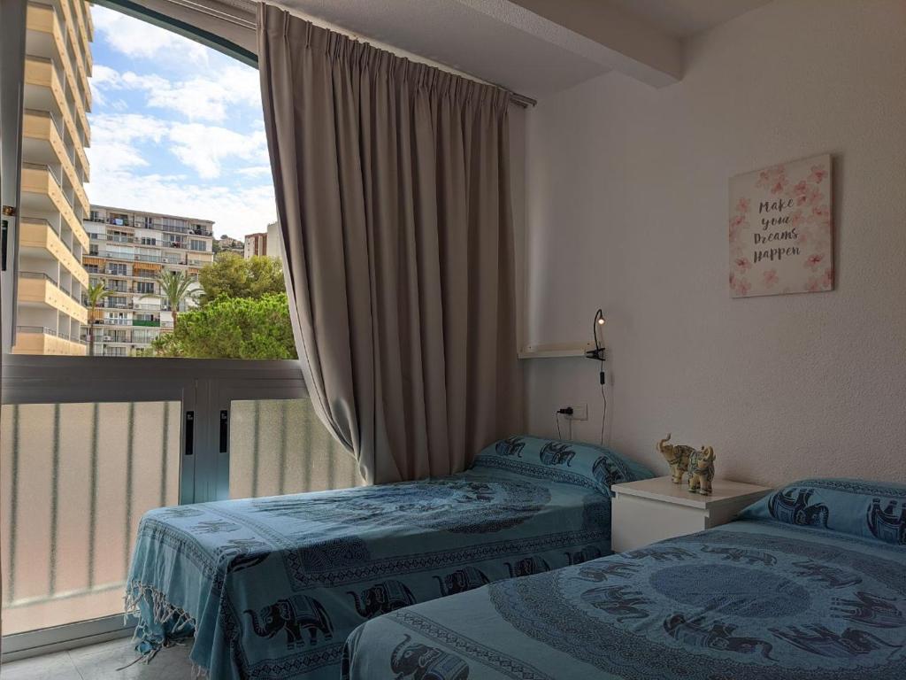 ベニドルムにあるSAN ANGELO Levante beach apartmentsのベッドルーム1室(ベッド2台、大きな窓付)