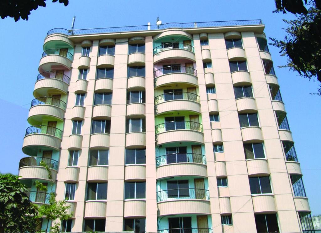 ein hohes Gebäude mit Balkonen darüber in der Unterkunft Naba Inn in Chittagong
