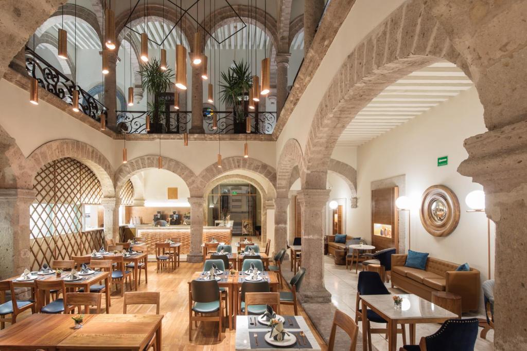 an interior view of a restaurant with tables and chairs at Hotel Herencia By Hosting House in Morelia