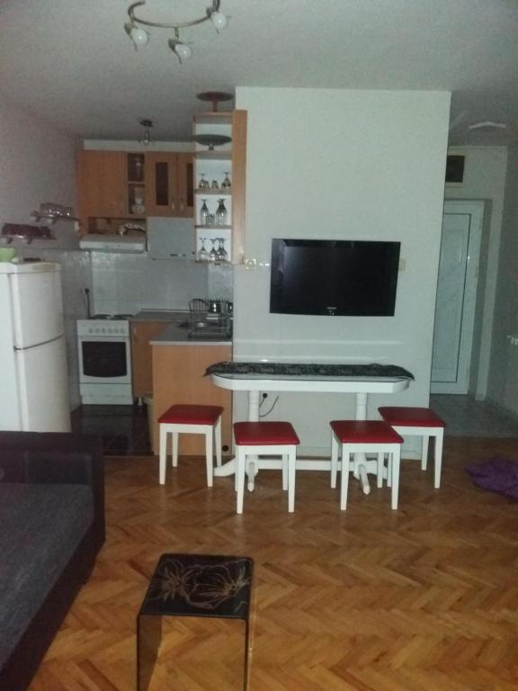 ein Wohnzimmer mit einem weißen Tisch und roten Stühlen in der Unterkunft APARTMAN MARKOVIC in Loznica