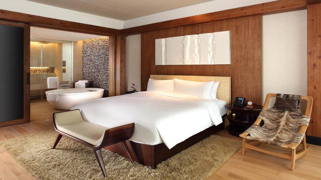 淳安県にあるインターコンチネンタル ワン サウザンド アイランド レイク リゾートのベッドルーム(大型ベッド1台付)、バスルームが備わります。