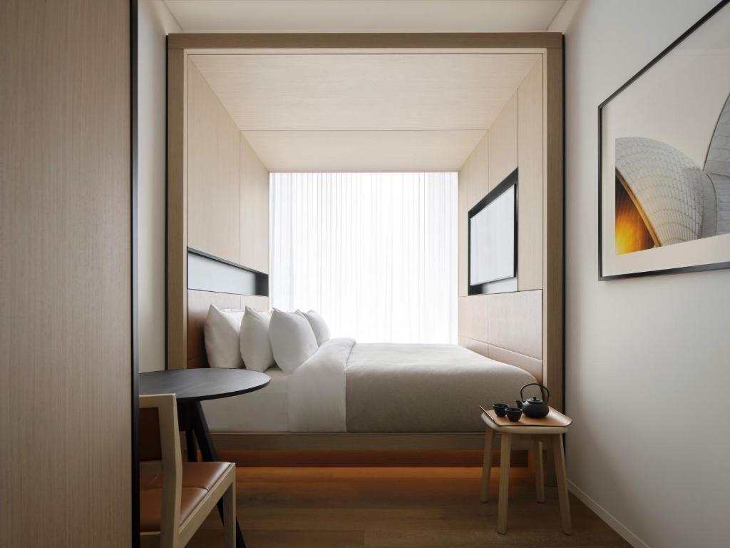 a bedroom with a bed and a table and a mirror at Little National Hotel Sydney in Sydney