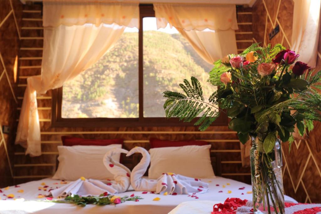 a bedroom with a bed with a bouquet of flowers at Dar Adouss in Imlil