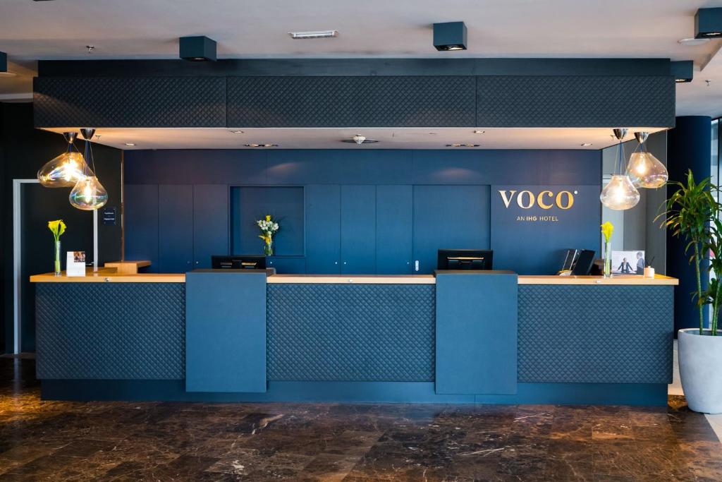 a blue wall with a vco counter in a room at voco® Villach, an IHG Hotel in Villach
