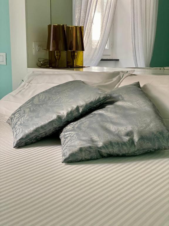 two pillows sitting on top of a bed at La Polena Camere Vernazza - Suite vista mare in Vernazza