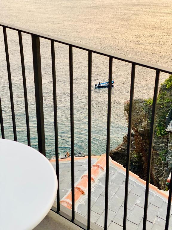 a balcony with a view of the ocean and a boat at La Polena Camere Vernazza - Suite vista mare in Vernazza
