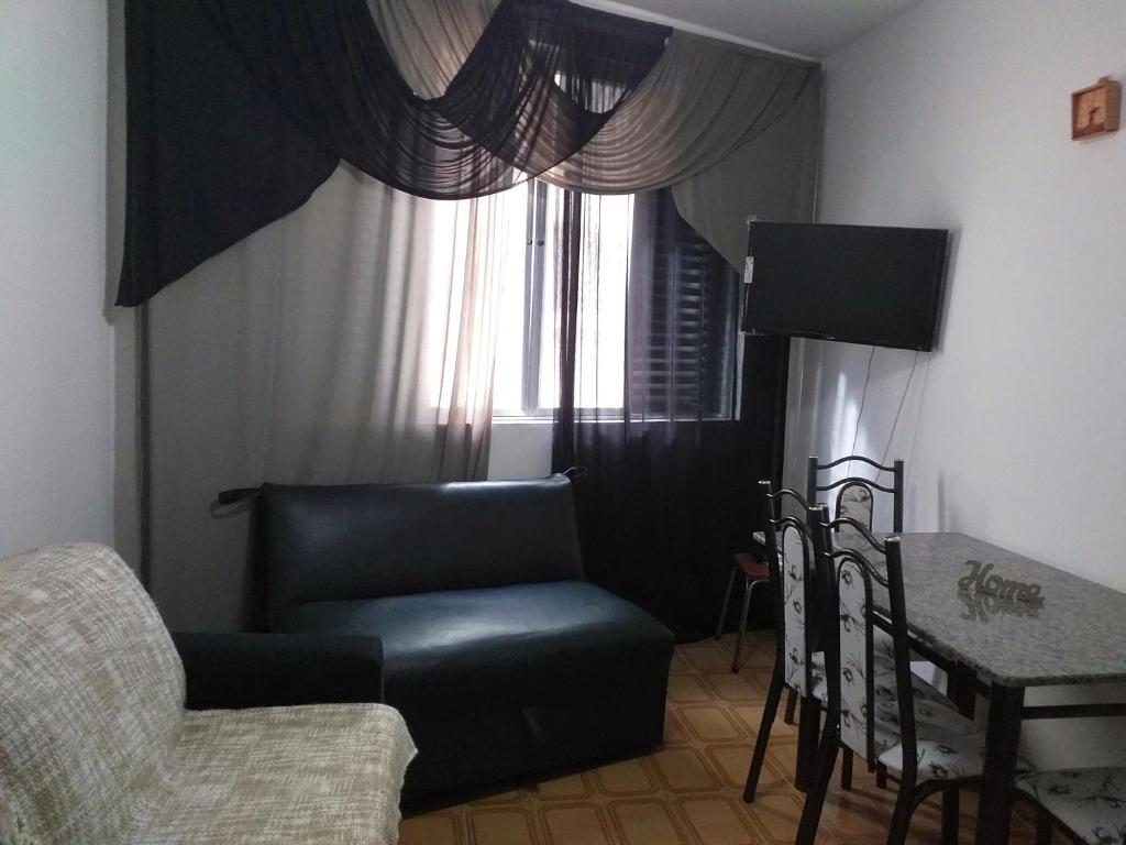 - un salon avec une chaise et une fenêtre dans l'établissement Apartamento Carrinho do Kuko n 309, à Praia Grande