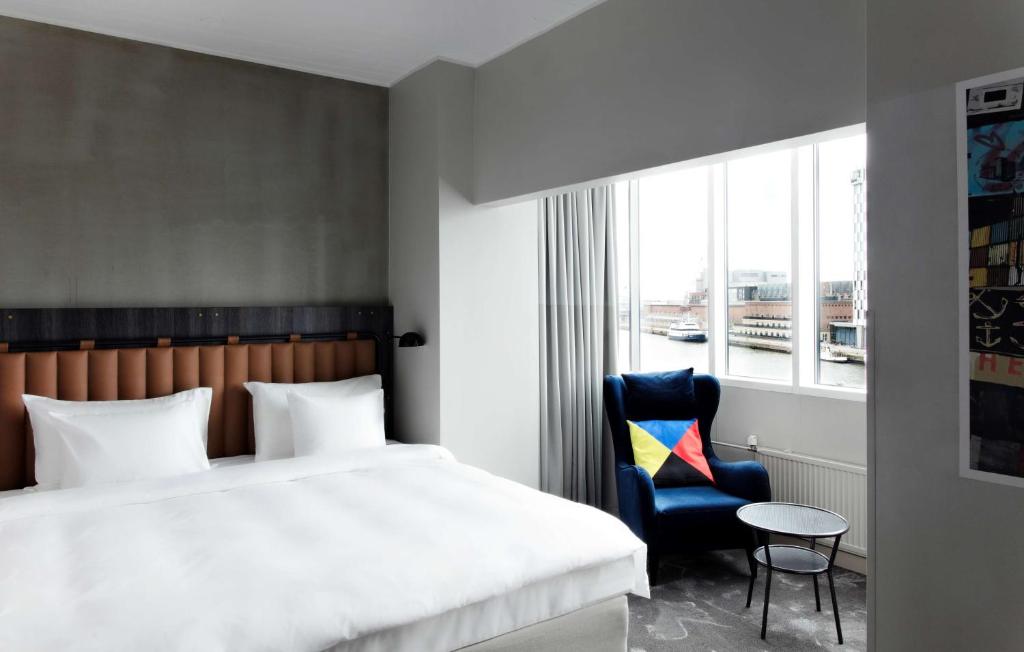a bedroom with a bed and a chair and a window at Radisson Blu Seaside Hotel, Helsinki in Helsinki