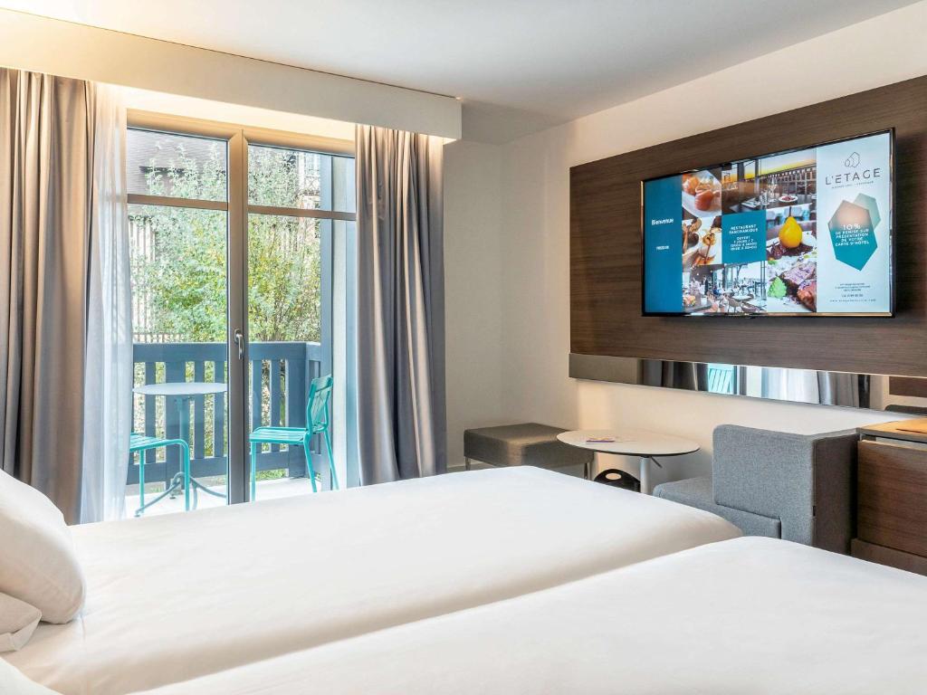 Кровать или кровати в номере Novotel Deauville Plage