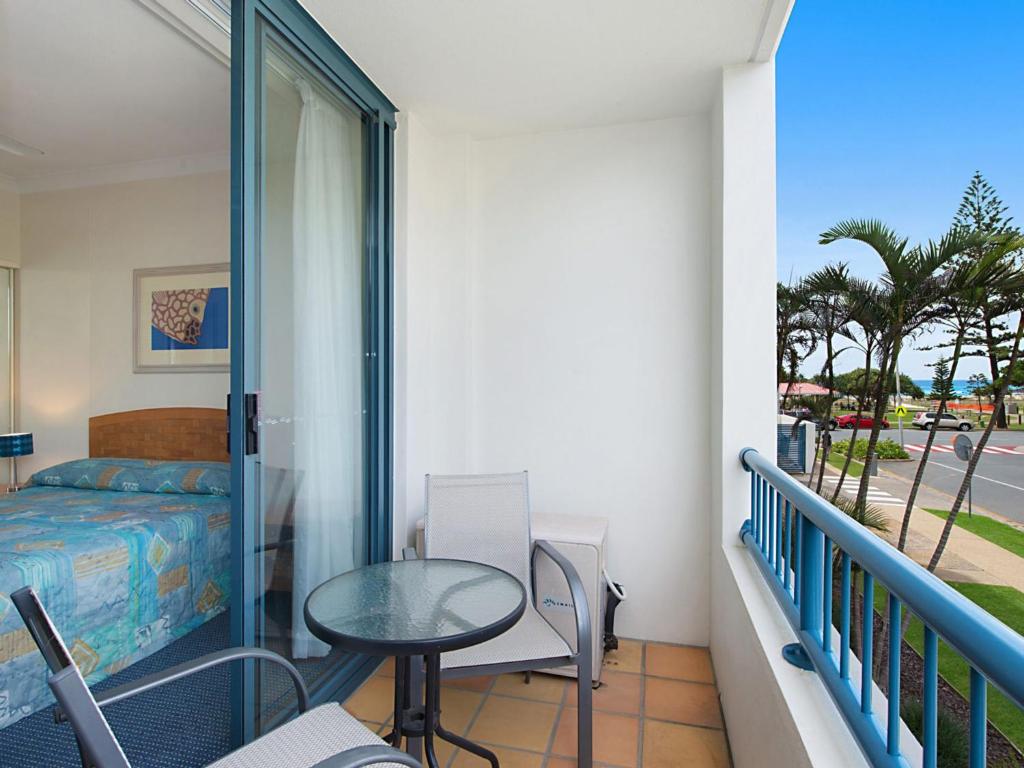 ein Schlafzimmer mit Balkon mit Bett und Tisch in der Unterkunft Calypso Plaza Resort Unit 146 in Gold Coast