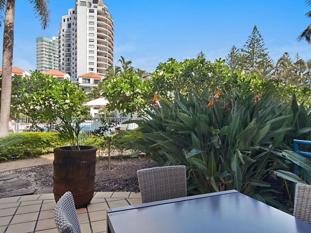a patio with a table and chairs and a building at Calypso Plaza Resort Unit 141 Studio style apartment - Beachfront Coolangatta in Gold Coast