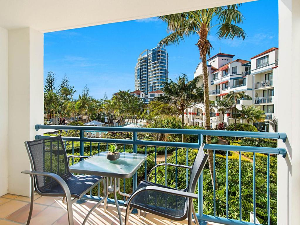 balcón con mesa, sillas y vistas a la ciudad en Calypso Plaza Resort Unit 215, en Gold Coast