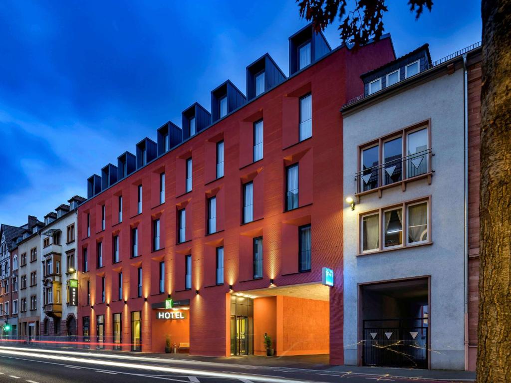 a red building on the side of a street at ibis Styles Aschaffenburg in Aschaffenburg