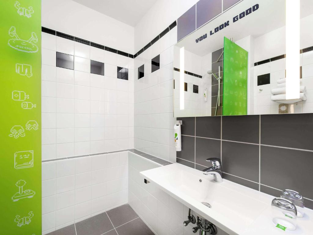 a white bathroom with a sink and a mirror at Ibis Styles Budapest Center in Budapest