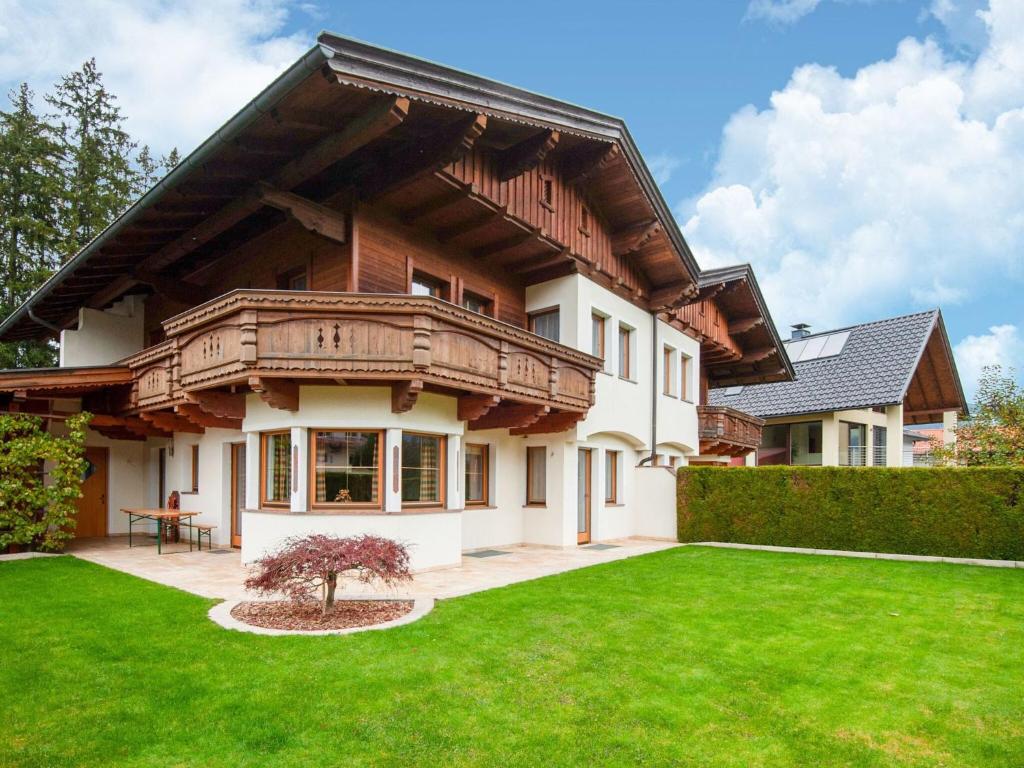 a house with a balcony and a lawn at Holiday house in Reith im Alpbachtal with garden in Reith im Alpbachtal