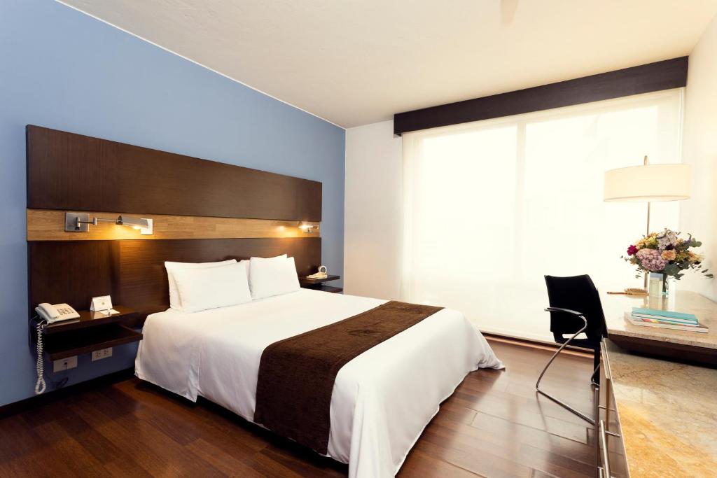 a hotel room with a large bed and a window at Mercure Bogota BH Retiro in Bogotá