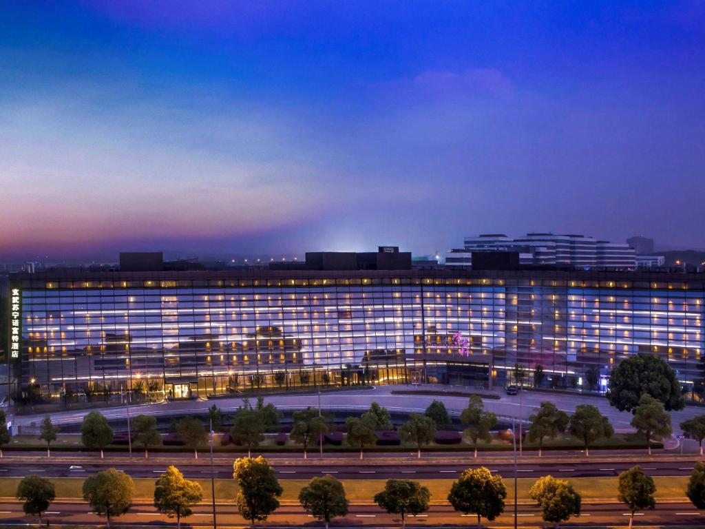 un gran edificio con luces encendidas por la noche en Novotel Nanjing East Suning en Nanjing