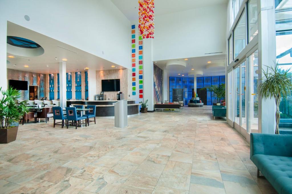 ein Büro mit einer Lobby mit Stühlen und einem Tisch in der Unterkunft Hotel Indigo Waco, an IHG Hotel in Waco