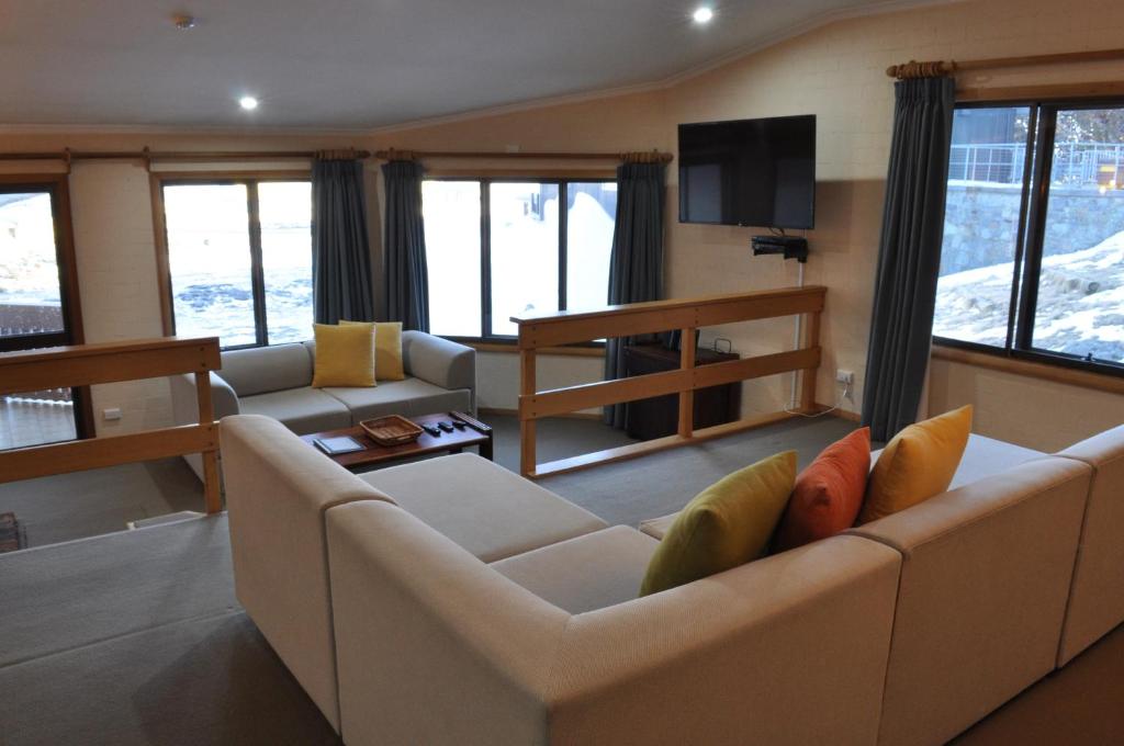 a living room with a couch and a tv at Salzburg Apartments in Perisher Valley