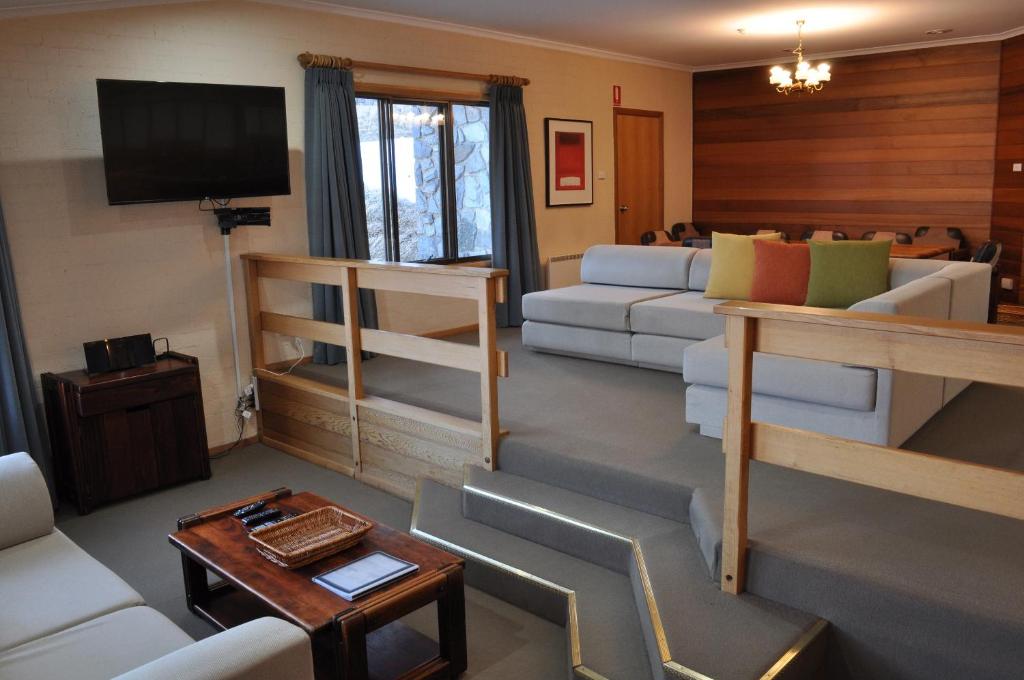 a living room with a couch and a tv at Salzburg Apartments in Perisher Valley