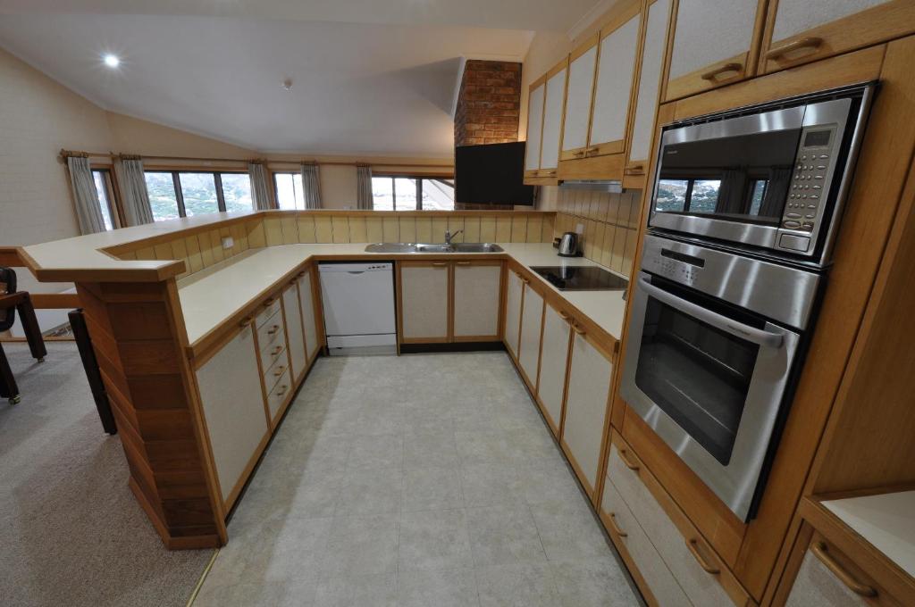 a kitchen with a stove and a microwave at Salzburg Apartments in Perisher Valley