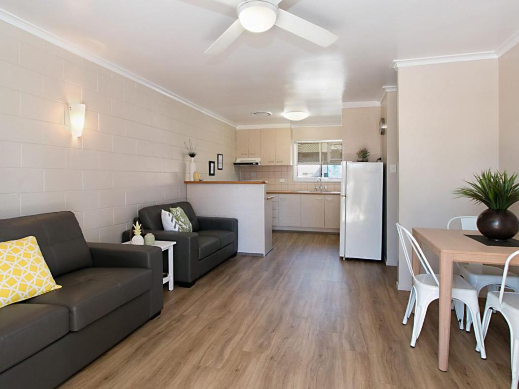 a living room with a couch and a table and a kitchen at Mavic Court Unit 4 in Gold Coast