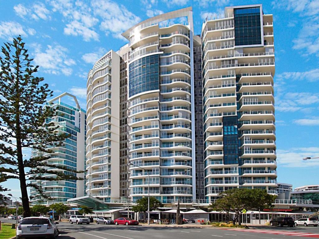 un edificio alto con macchine parcheggiate di fronte di Reflections tower 2 Unit 401 a Gold Coast