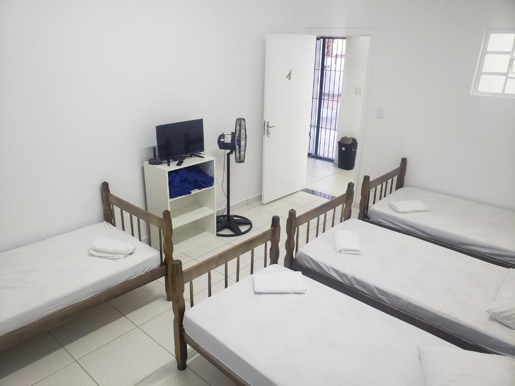 a room with three bunk beds and a phone at Pousada alojacampinas in Viracopos