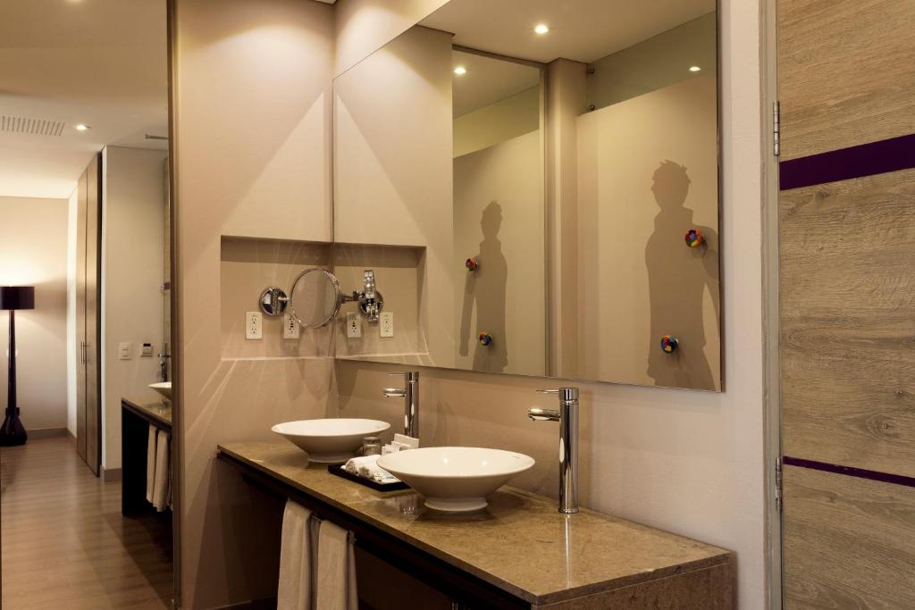 a bathroom with two sinks and a large mirror at Mercure Bogota BH Zona Financiera in Bogotá