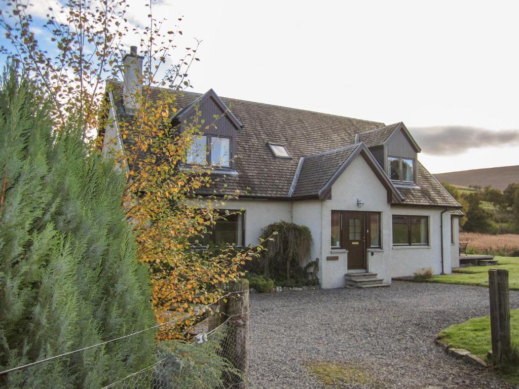 una casa bianca con una recinzione davanti di Corriemhor Beag a Cromdale