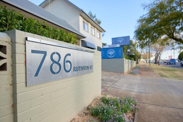 uma casa com uma placa na lateral de um edifício em Ruthven Street Motor Inn em Toowoomba