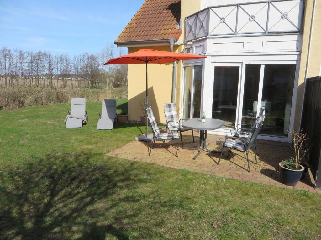 a patio with a table and chairs and an umbrella at Ferienanlage-Reriker-Strasse-Bella-Vista-736 in Kühlungsborn