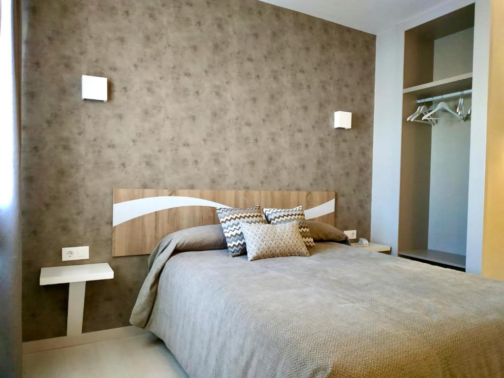 1 dormitorio con 1 cama grande y cabecero de madera en Hotel Los Conejos, en Mora
