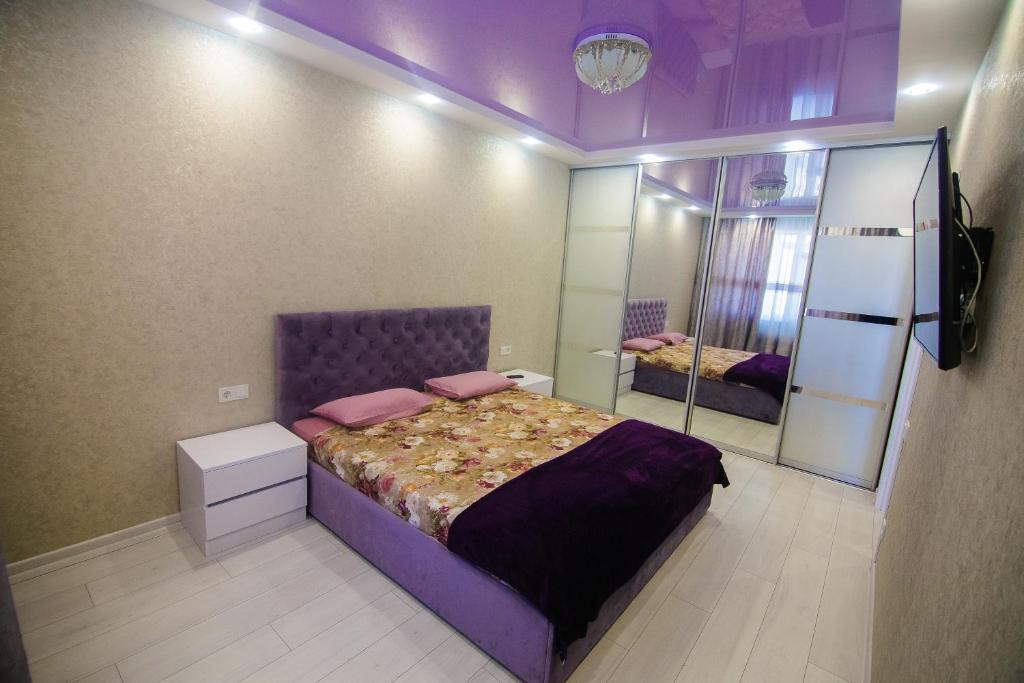 a bedroom with a large bed and a mirror at Pearl of Odessa in Odesa