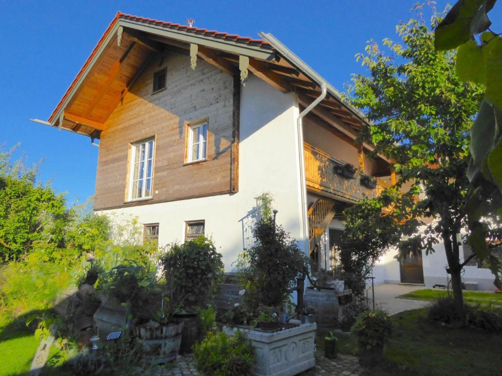 uma grande casa branca com um telhado de madeira em Ferienwohnung Schreiner-Viehhausen em Grassau